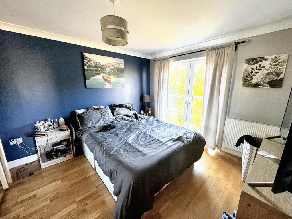 This inviting double bedroom features a cozy at...