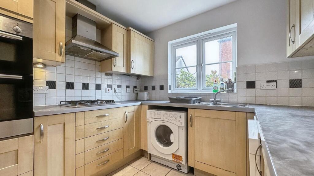 A clean and well-lit kitchen with modern applia...
