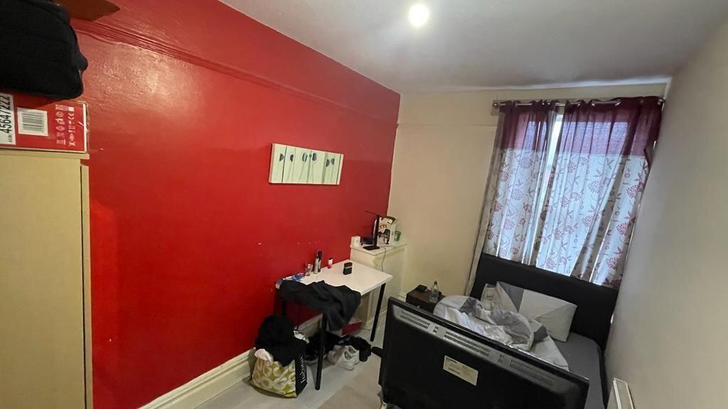 Cozy single bedroom featuring a dark sofa bed a...