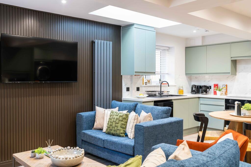 A modern, well-lit living room featuring a larg...