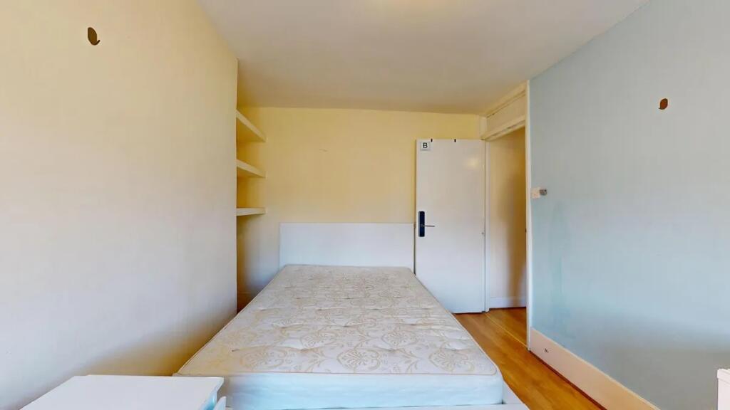 Compact bedroom featuring a clean mattress and ...