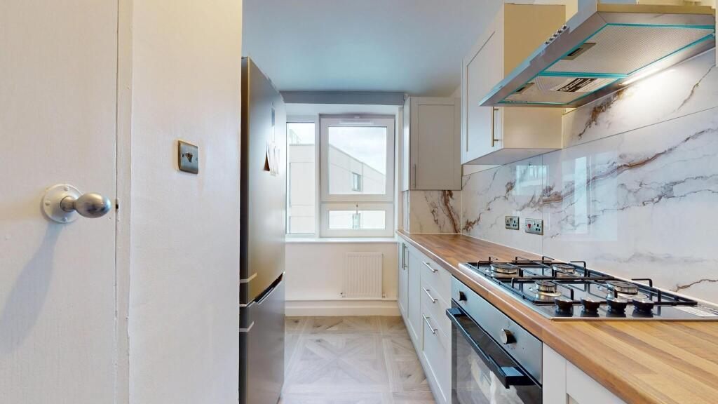 Bright and modern kitchen featuring sleek marbl...