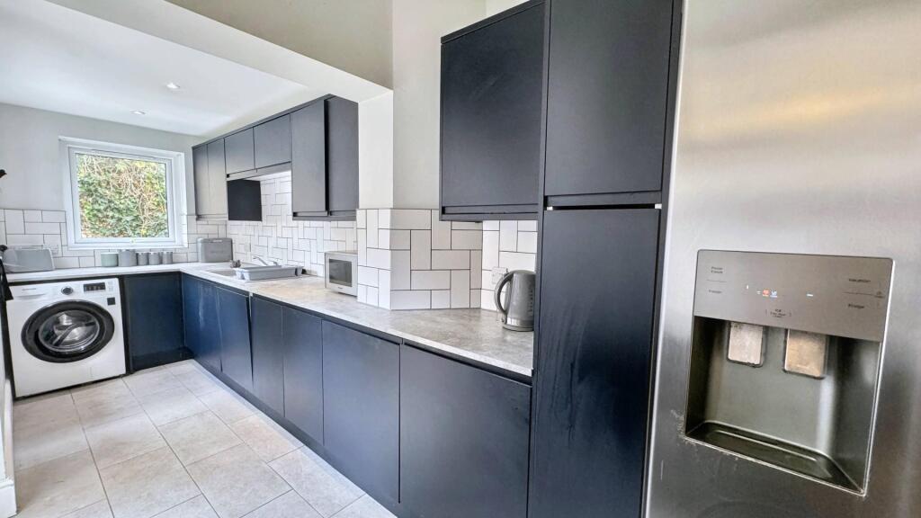 Modern kitchen with sleek black cabinetry, inte...