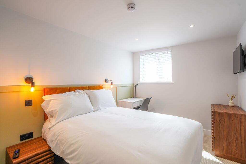 Modern and cozy double bedroom featuring a neat...