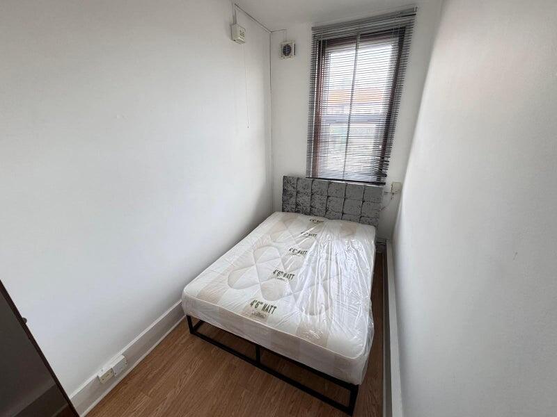 A tidy single bedroom featuring a clean mattres...