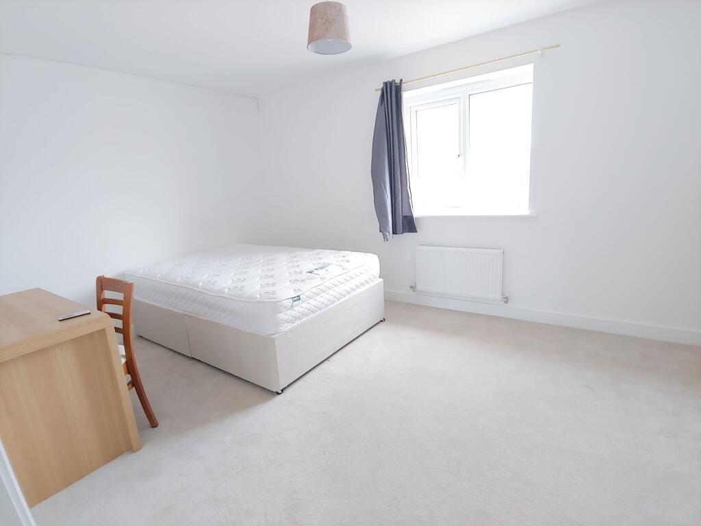 Bright, minimally furnished double bedroom with...