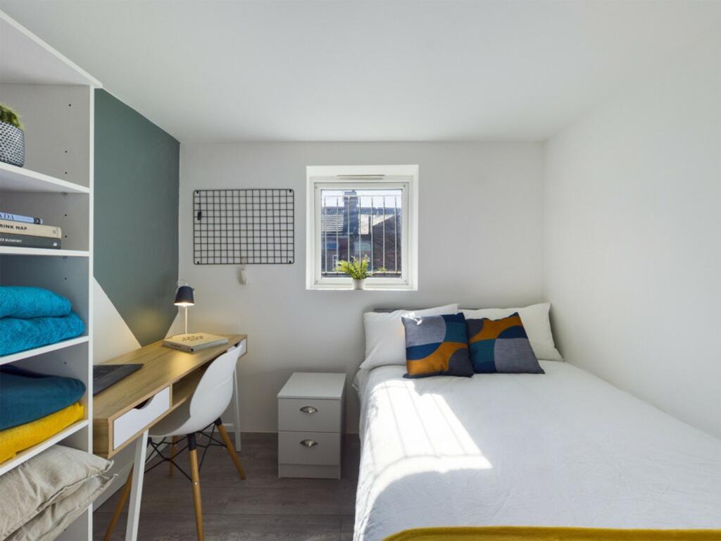 A bright and inviting double bedroom with a coz...