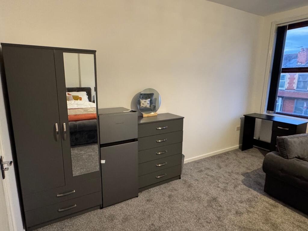 A spacious master bedroom featuring modern dark...