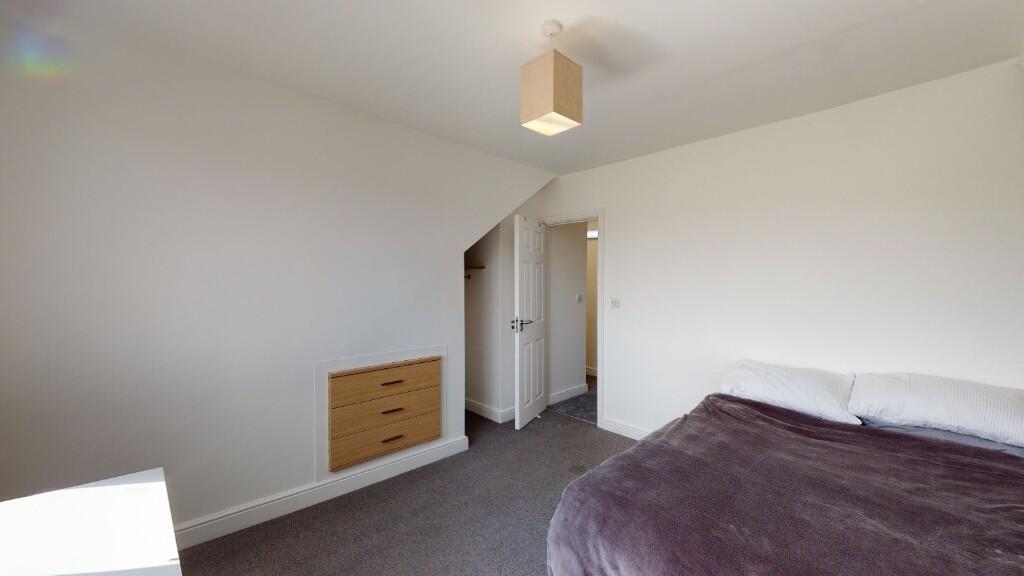A neat and well-lit double bedroom featuring a ...