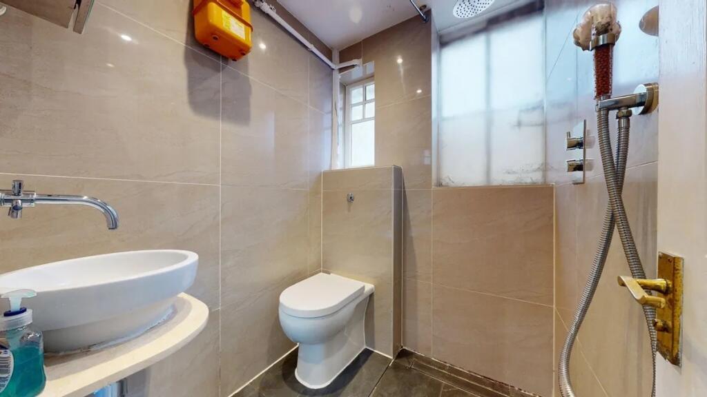 A clean and modern single toilet room featuring...