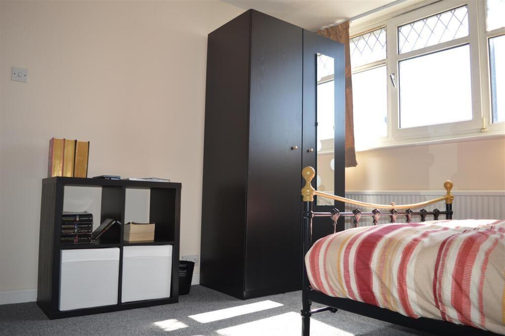 This charming double bedroom features a cozy at...