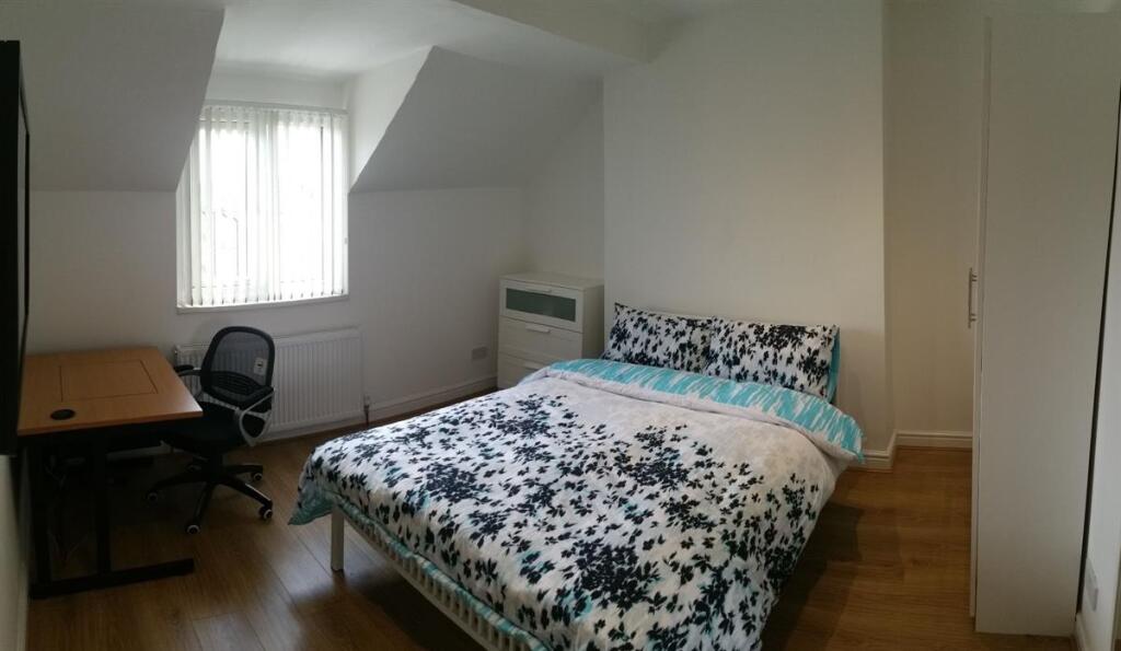 Bright, simply furnished bedroom with a pattern...