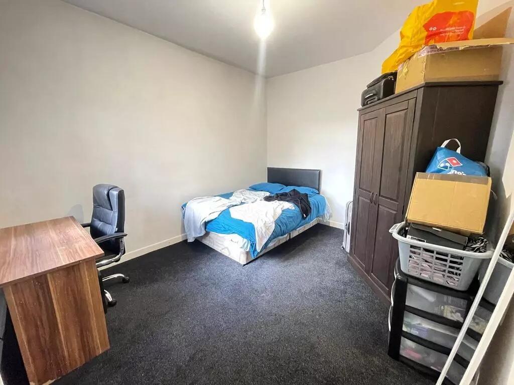 A modestly sized single bedroom featuring a com...