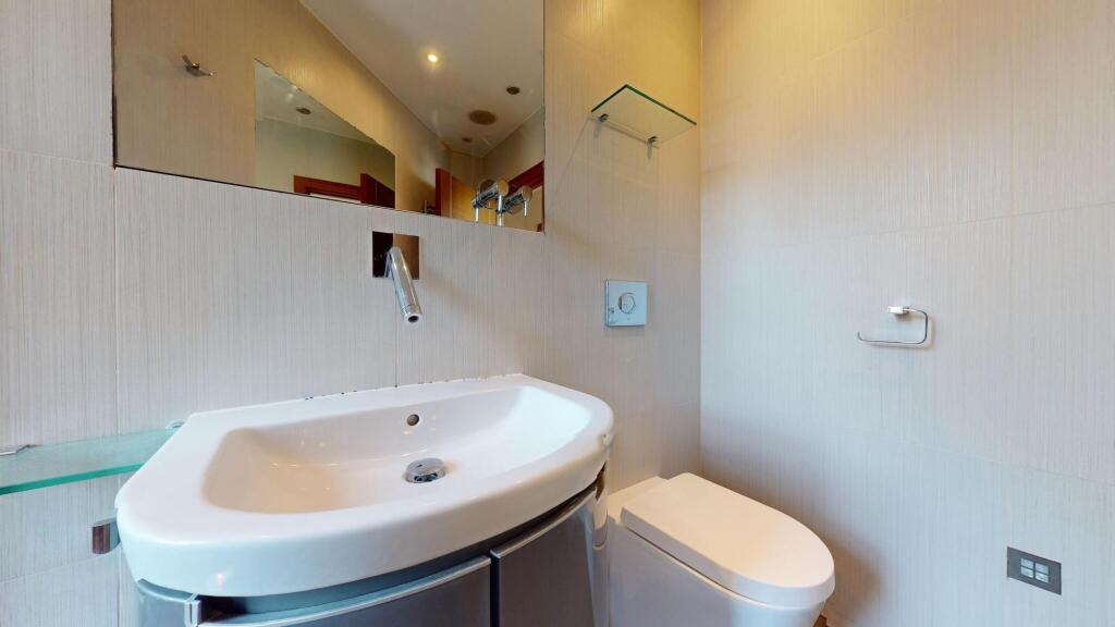 A modern bathroom featuring a sleek white sink ...