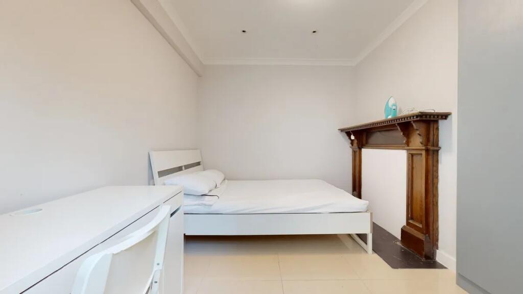 A clean and minimalist bedroom featuring a whit...