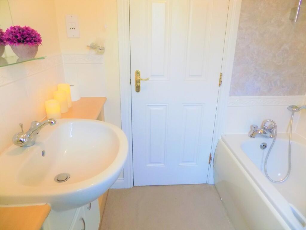 A bright and clean bathroom suite featuring a w...