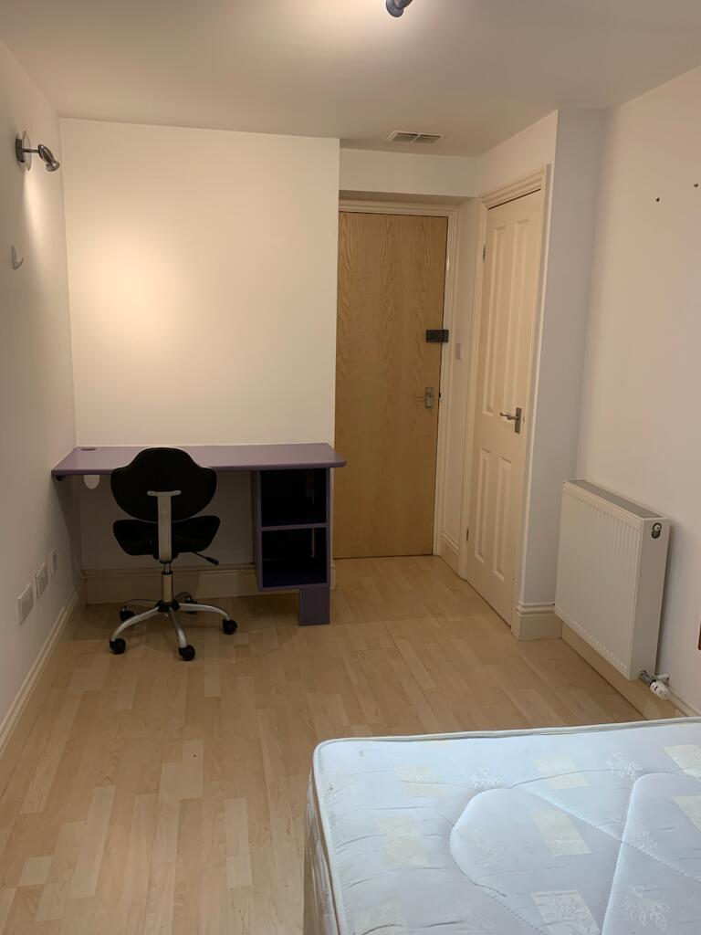 A spacious double bedroom featuring a study des...