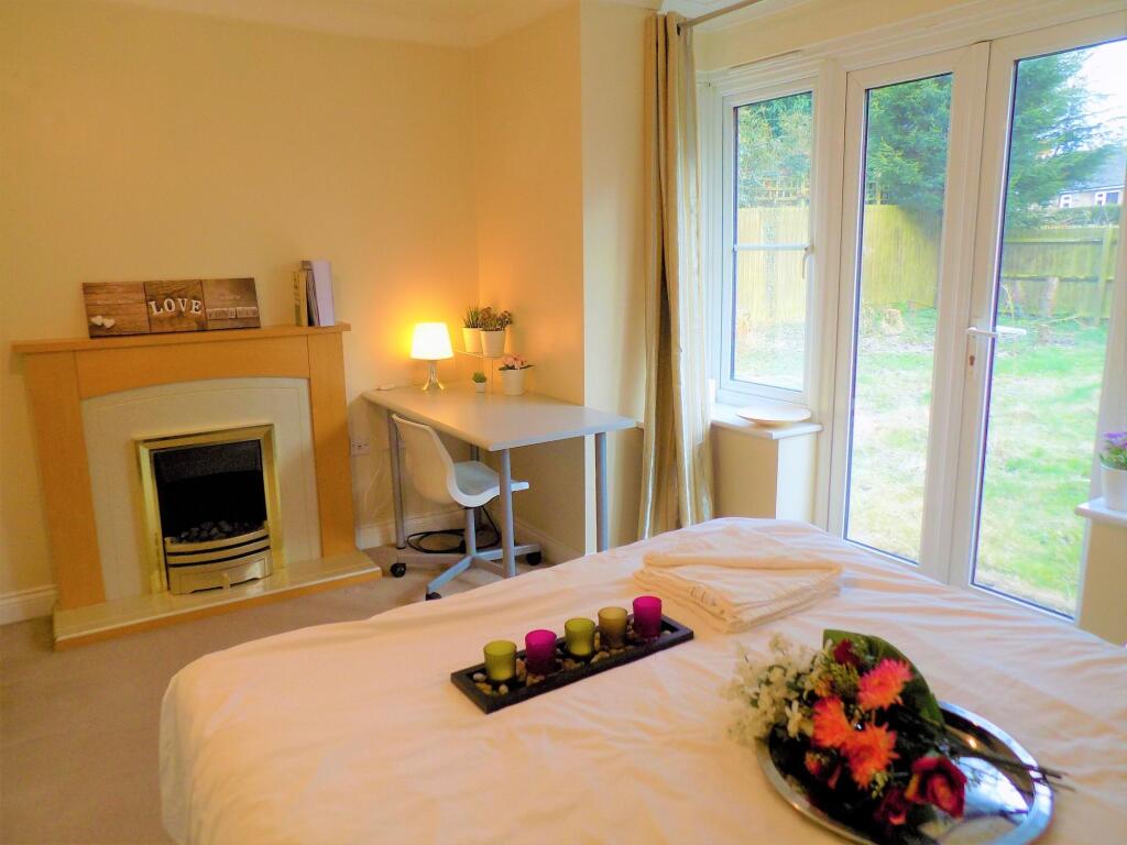 A cozy and bright master bedroom featuring a co...