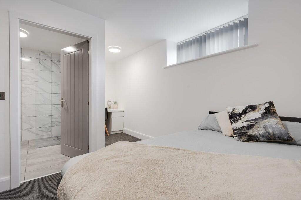 This inviting double bedroom features a spaciou...