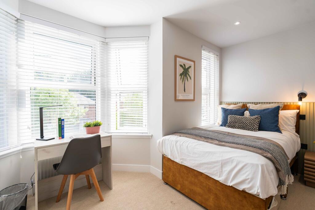 Bright and inviting double bedroom with a large...
