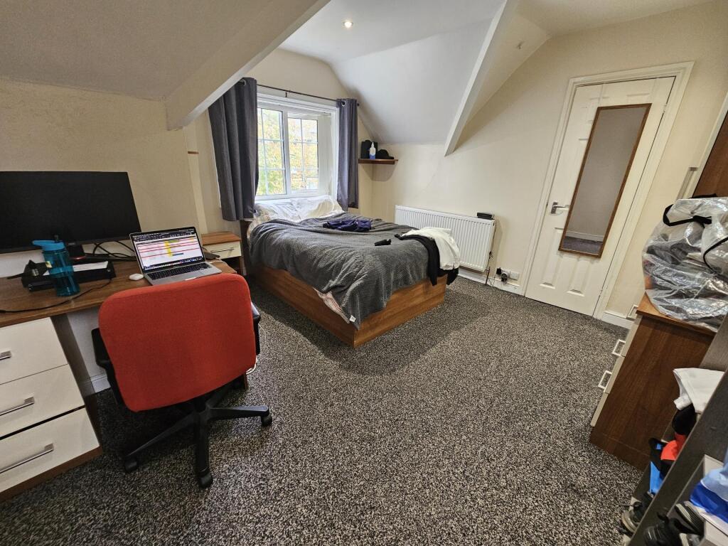 A comfortable and well-lit double bedroom featu...