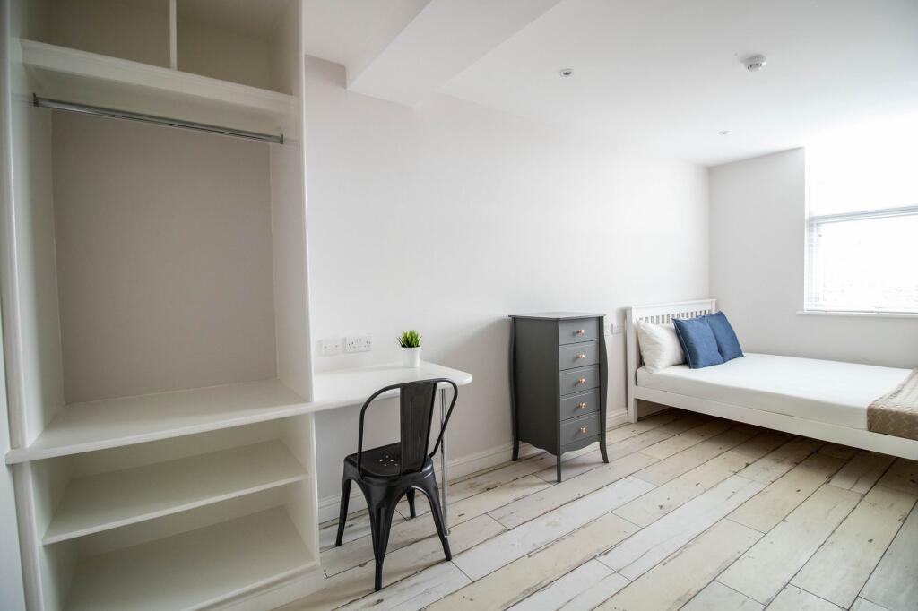 Bright and airy bedroom featuring a white bed w...