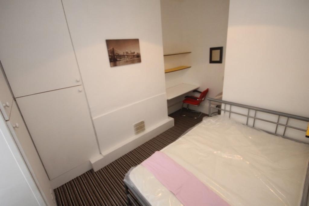 Cozy single bedroom featuring a comfortable bed...