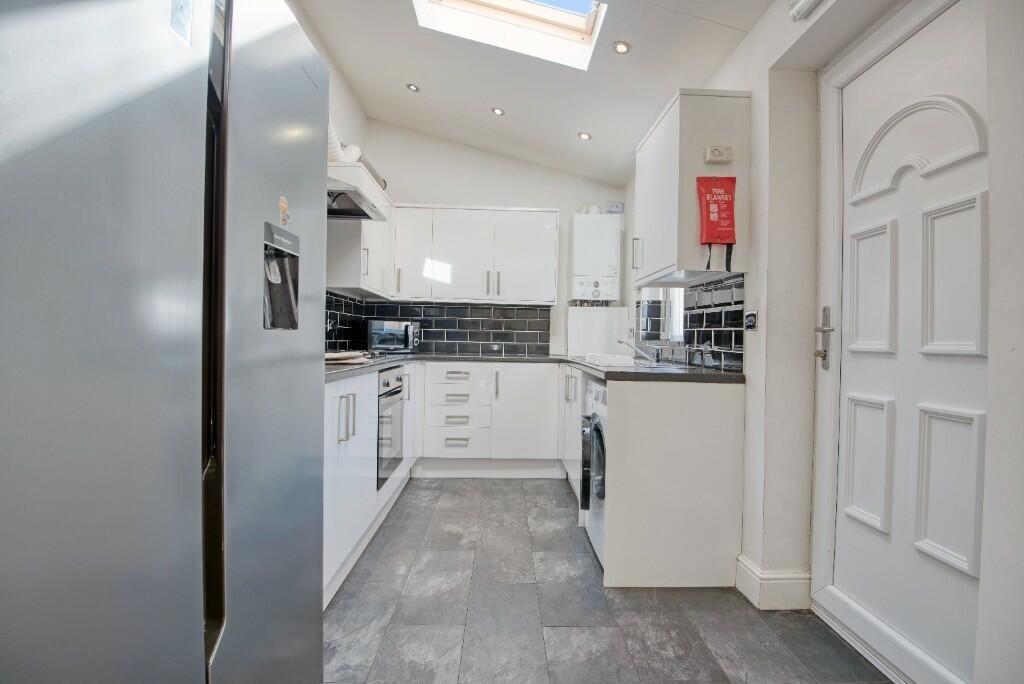 A modern kitchen featuring sleek white cabinetr...
