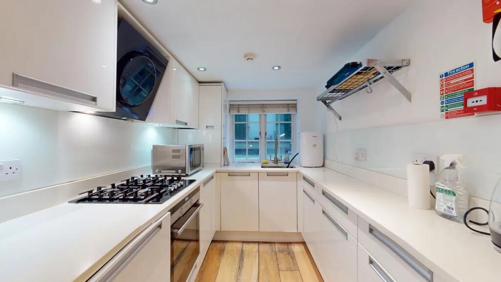 A modern, well-lit kitchen featuring sleek whit...