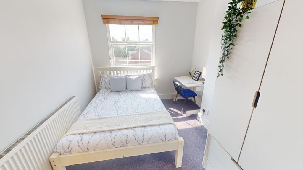 Bright and cozy single bedroom featuring a neat...