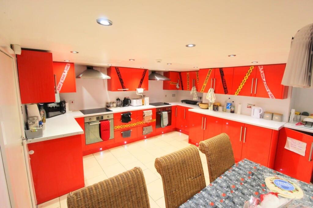 Bright modern kitchen with bold red units, inte...