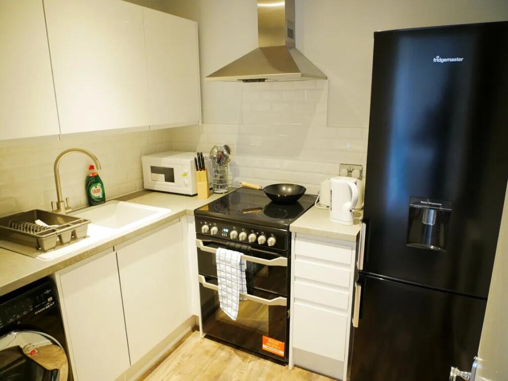 Bright and modern kitchen featuring sleek white...