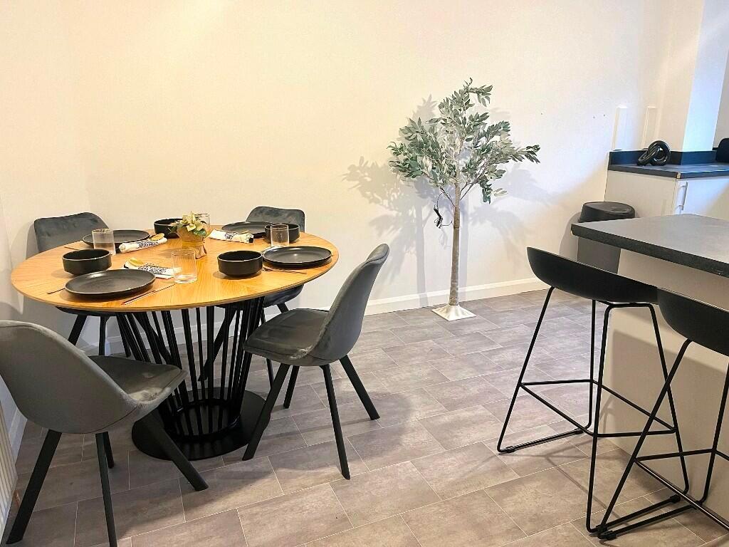 A modern kitchen and dining area featuring a ro...
