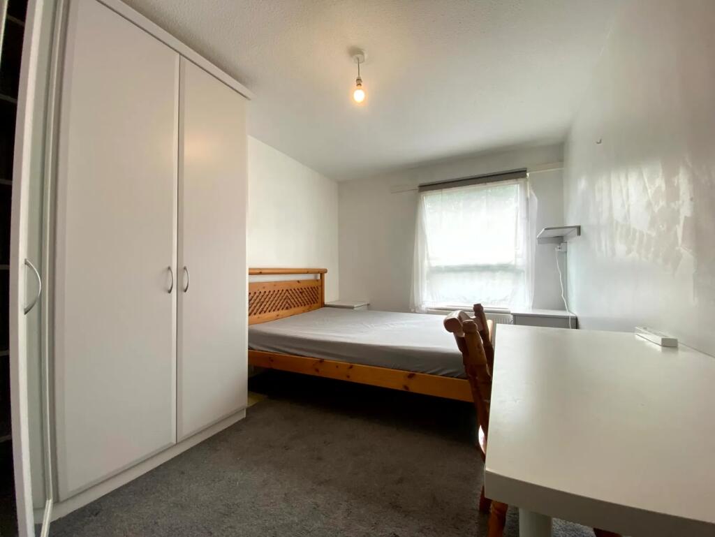 A simple and tidy double bedroom featuring a wo...