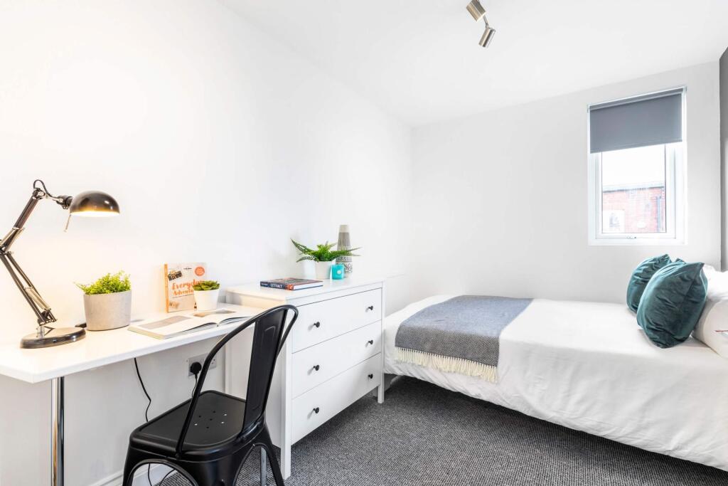 Bright, neatly presented bedroom with a comfort...