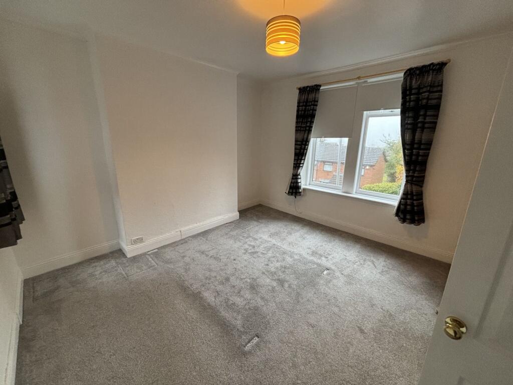 A bright double bedroom with a large window all...