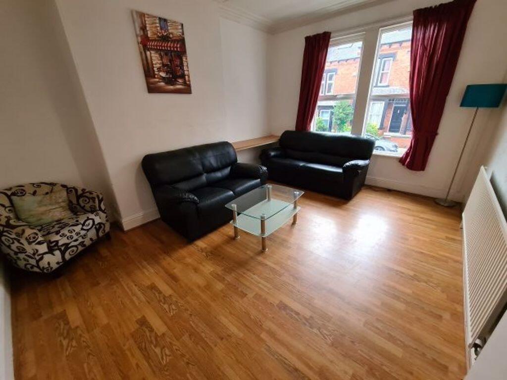 A spacious living room with wooden flooring, tw...