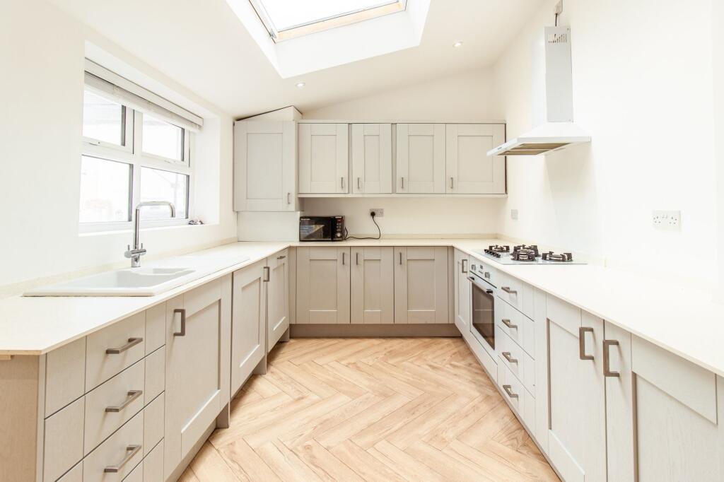 Bright and airy kitchen featuring ample counter...