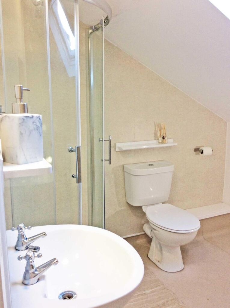 Bright, well-maintained bathroom with a corner ...