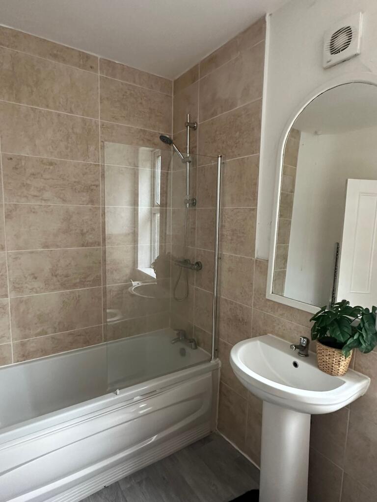 Modern bathroom featuring a spacious bathtub wi...