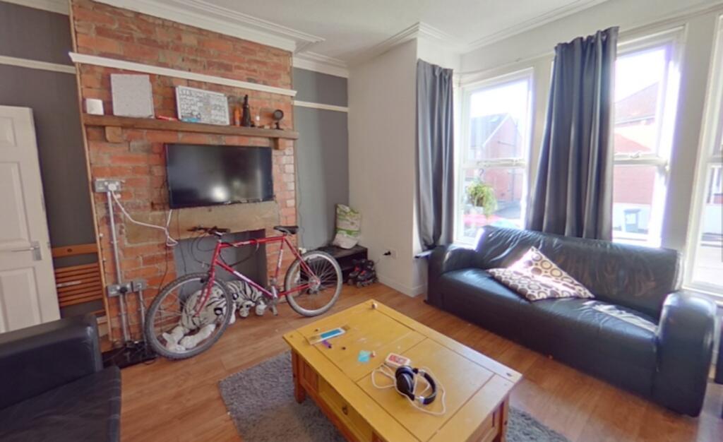 A cozy living room featuring an exposed brick w...