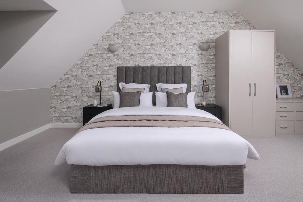 The main bedroom benefits from a high ceiling from being on the top floor