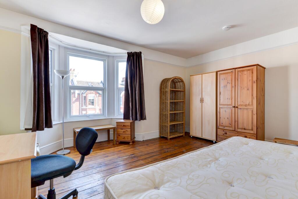 Bright double bedroom featuring a large window ...