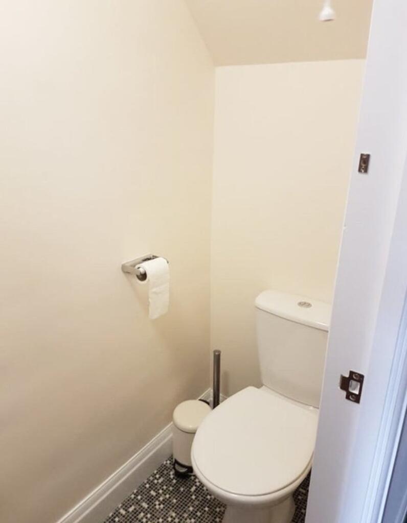 A clean and tidy single toilet with modern fixt...