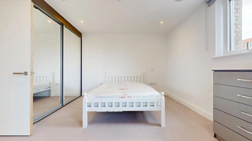 A bright and clean double bedroom featuring a w...