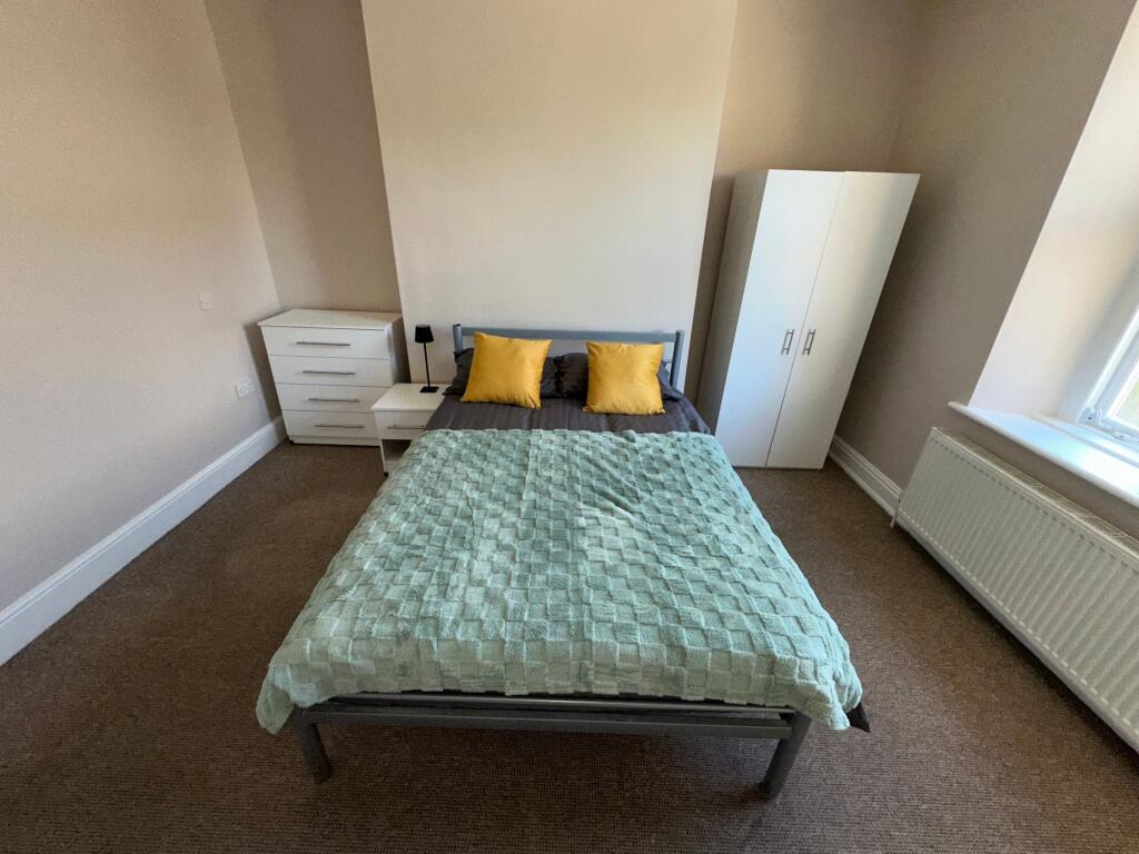 A clean and simple double bedroom featuring a n...