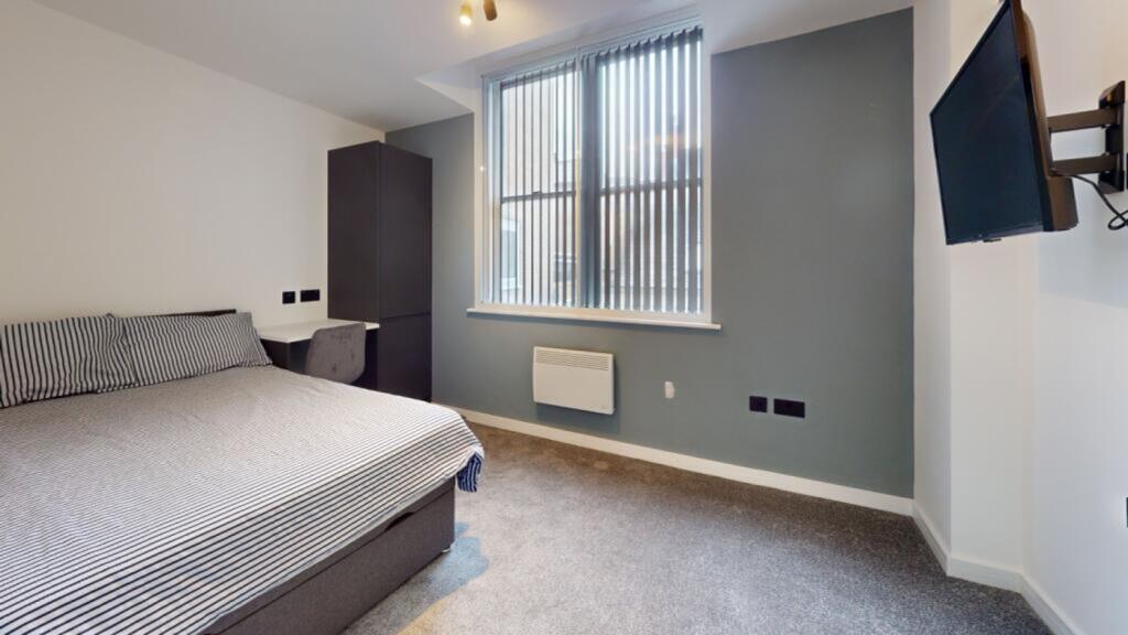 A spacious and well-lit double bedroom featurin...