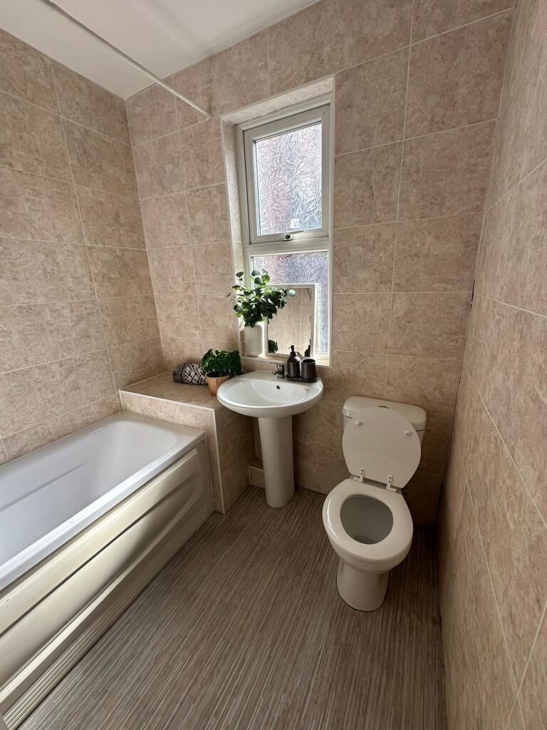 Bright and clean bathroom with a bathtub, a sma...