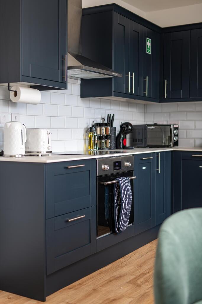 Modern kitchen with stylish dark blue cabinetry...