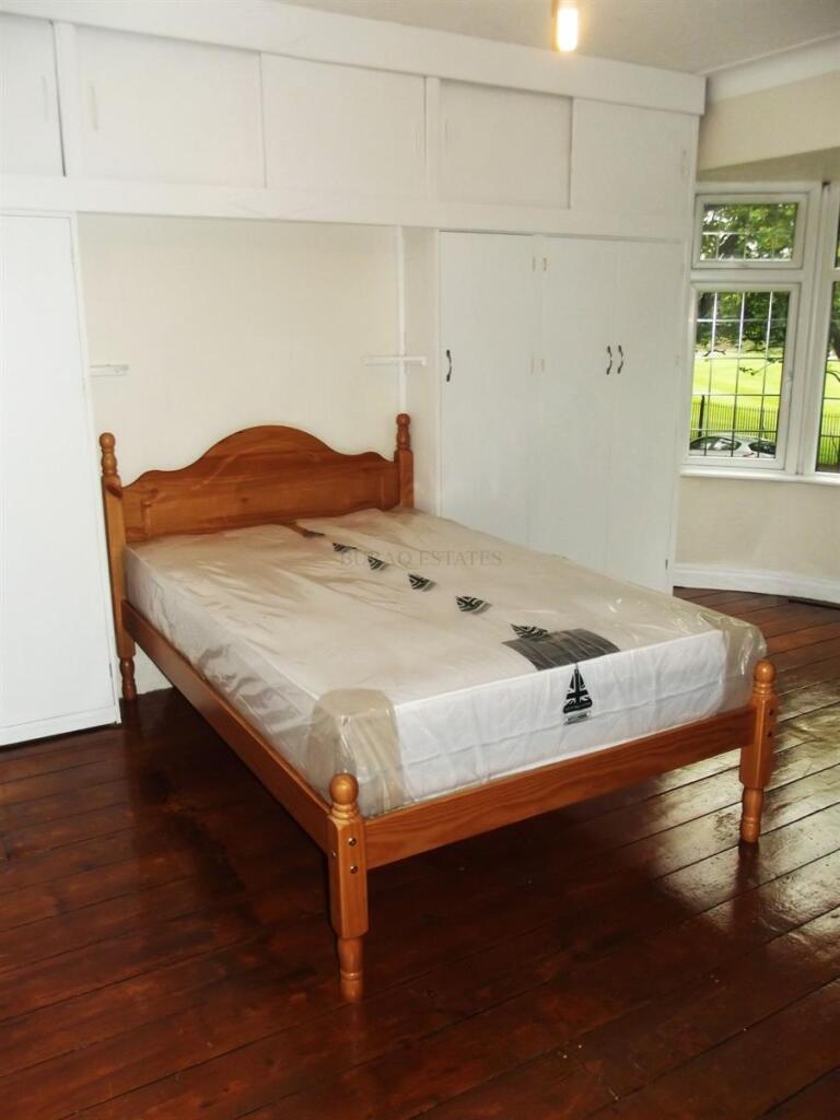 Bright bedroom with wooden bedframe, built-in w...